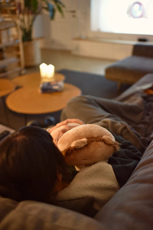 Vrouw kijkt tv met een kudl verzwaringsknuffel