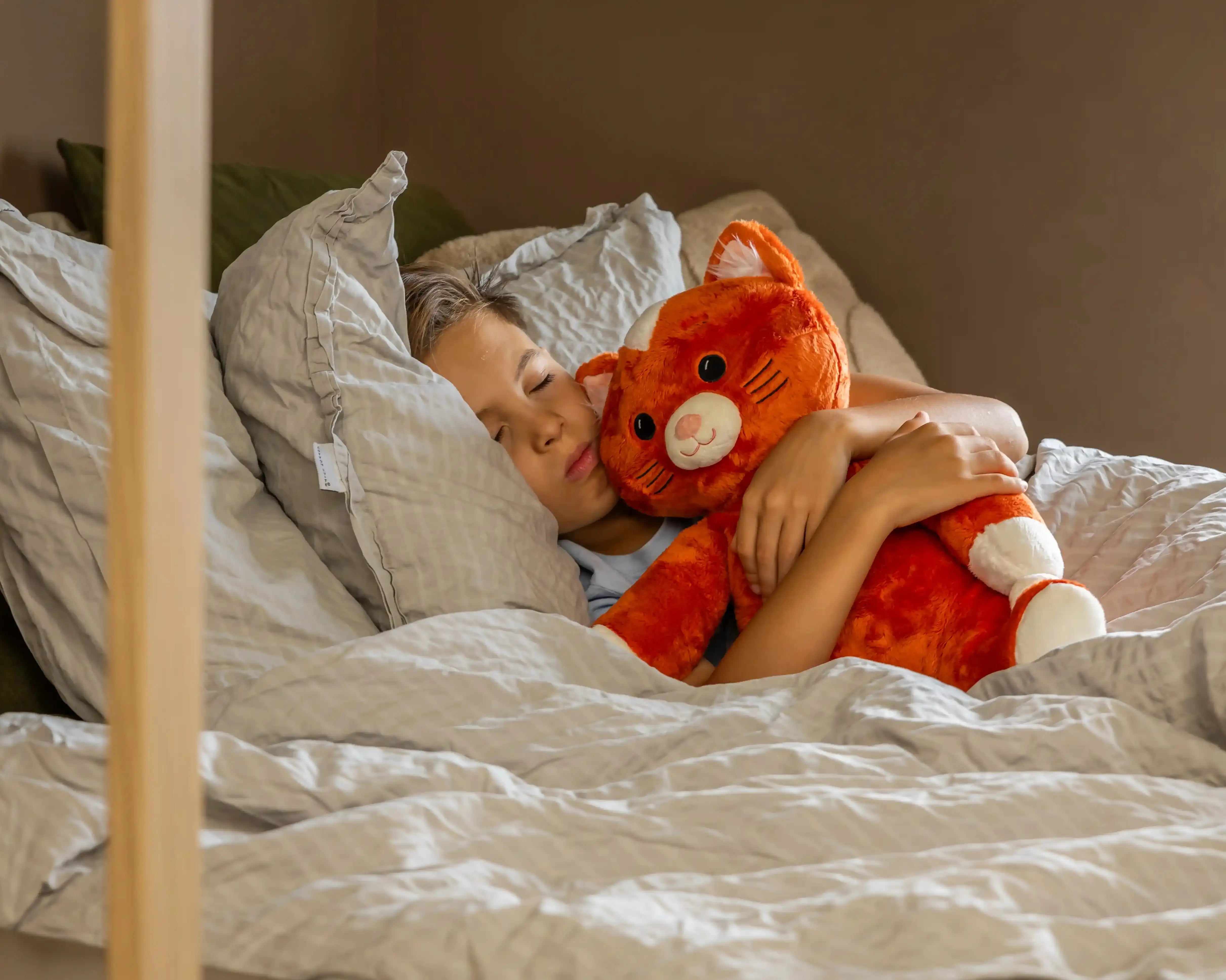 Jongen in bed met KUDL Leeuw Verzwaringsknuffel met Hartslag