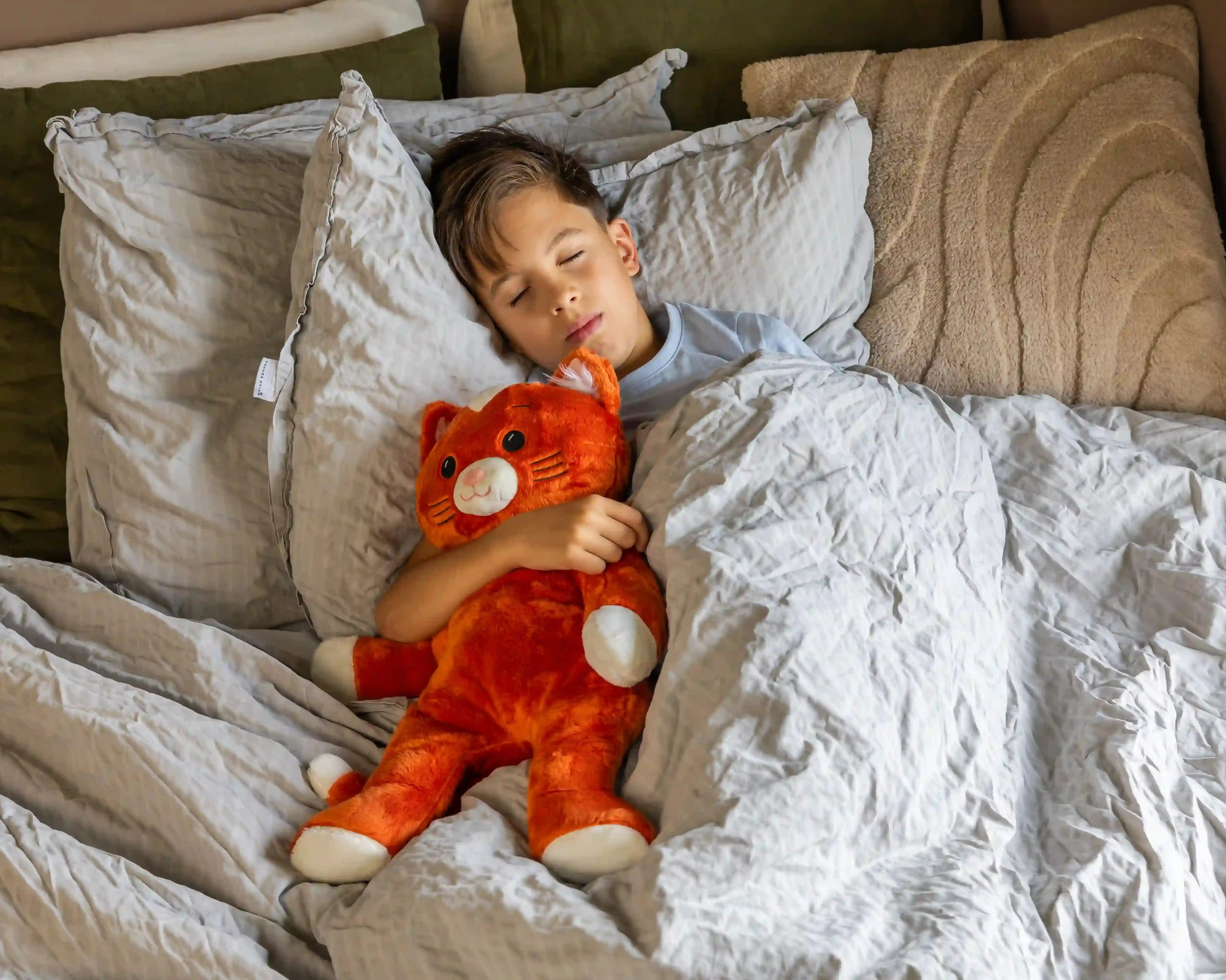 Jongen in bed met Kiki de verzwaringsknuffel op zijn borst