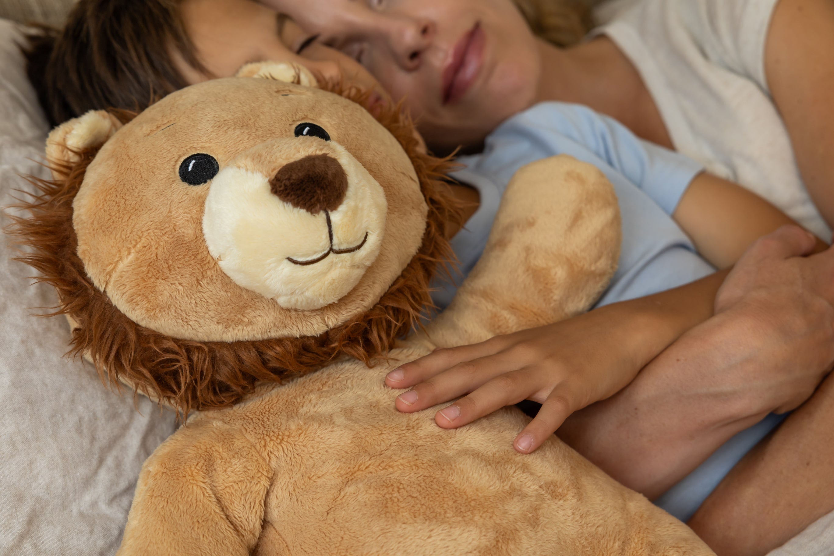 Ludo de leeuw verzwaringsknuffel met hartslag in bed met moeder en zoon