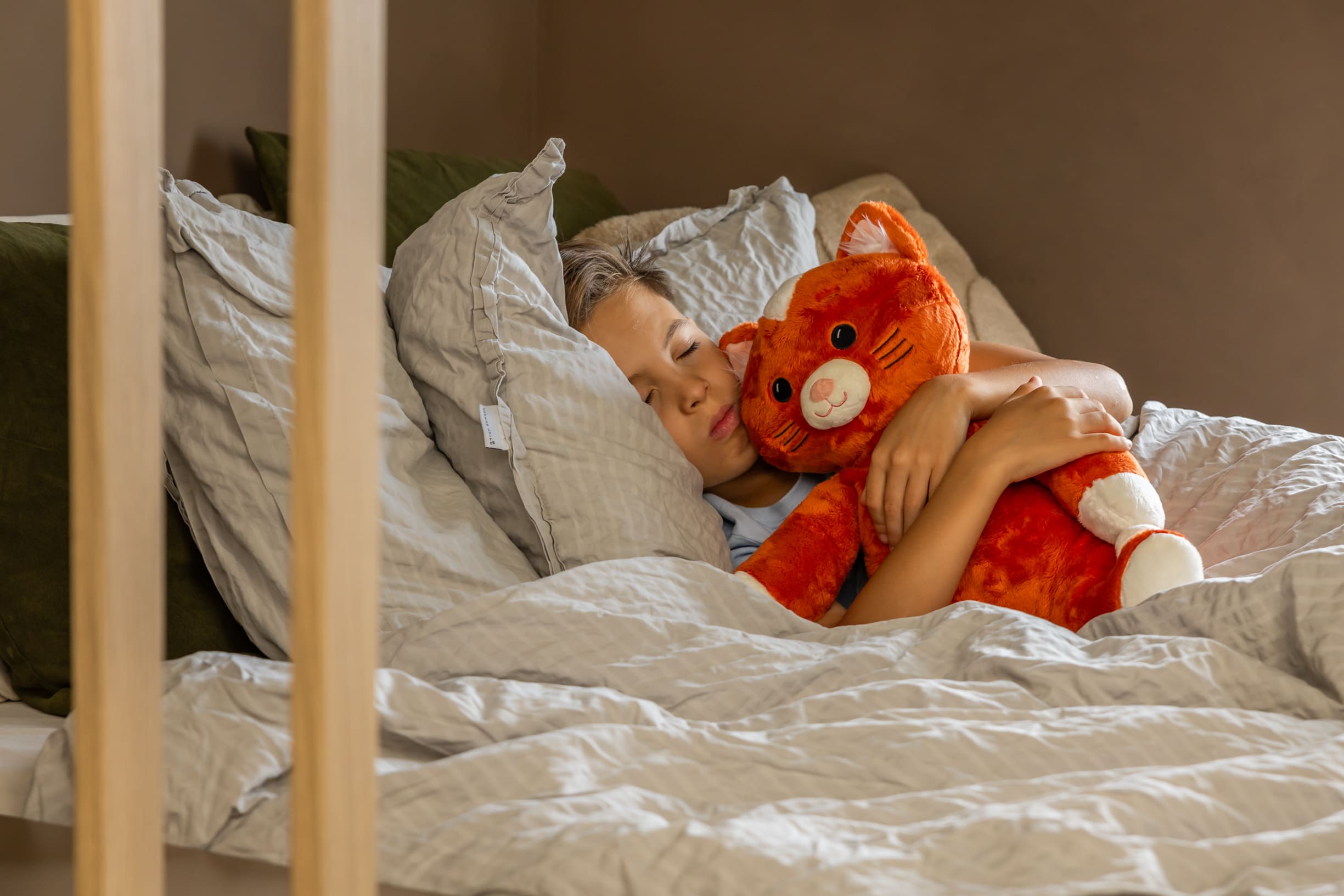 Jongen in bed met KUDL Verzwaringsknuffel met Hartslag