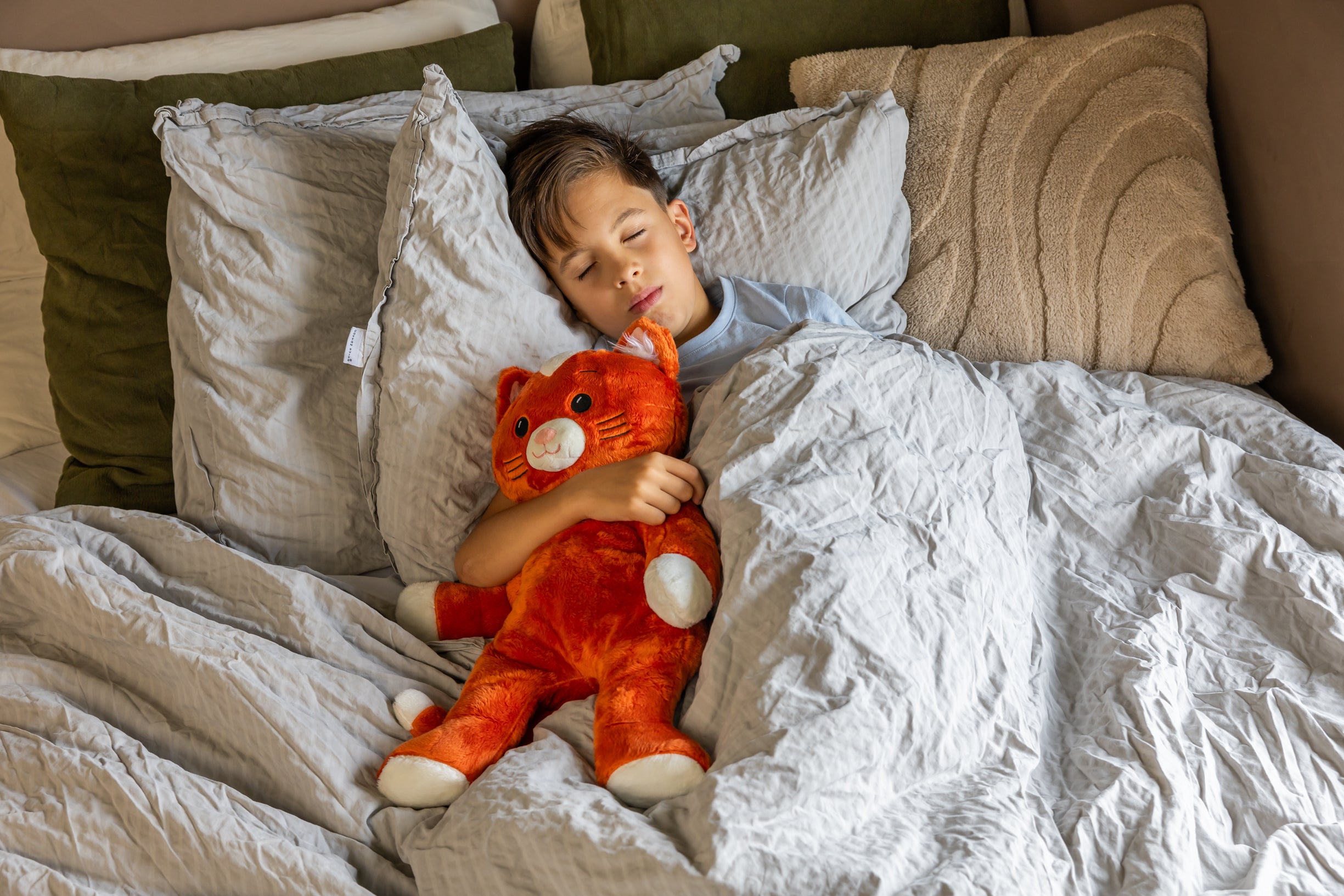 Jongen in bed met KUDL Verzwaringsknuffel met Hartslag